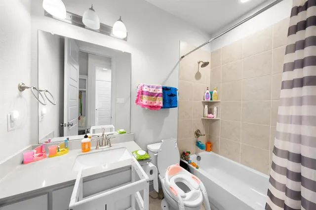 a bathroom with a sink mirror vanity and bathtub