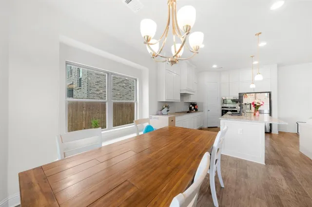 a view of a dining room with furniture a chandelier and wooden floor