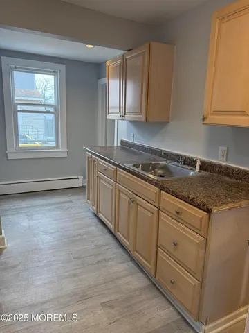 a kitchen with granite countertop a stove a sink and a microwave