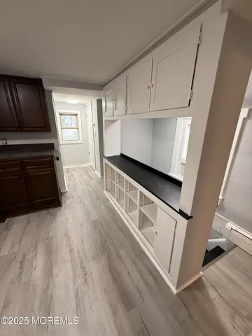 a kitchen with granite countertop white cabinets and white appliances