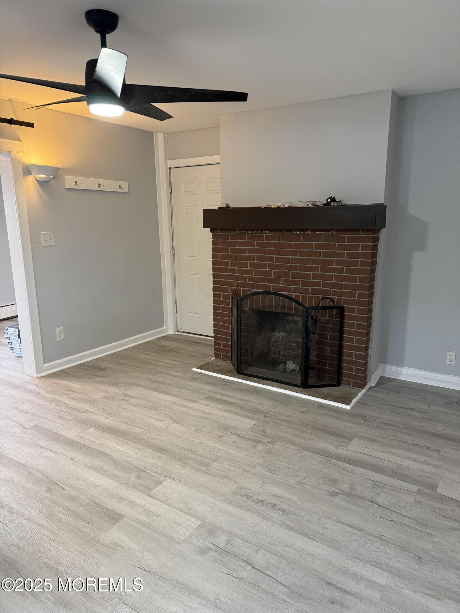 79 Pine View Avenue Keansburg, NJ 07734 - Photo 2 of 20 a view of an empty room with wooden floor fireplace and a window