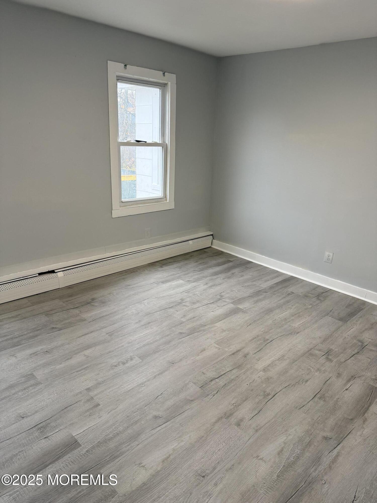 79 Pine View Avenue Keansburg, NJ 07734 - Photo 7 of 20 an empty room with wooden floor and windows
