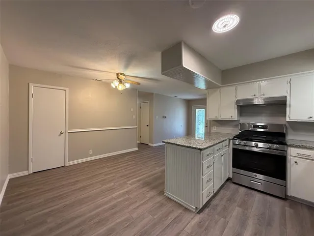a kitchen with granite countertop a stove and a refrigerator