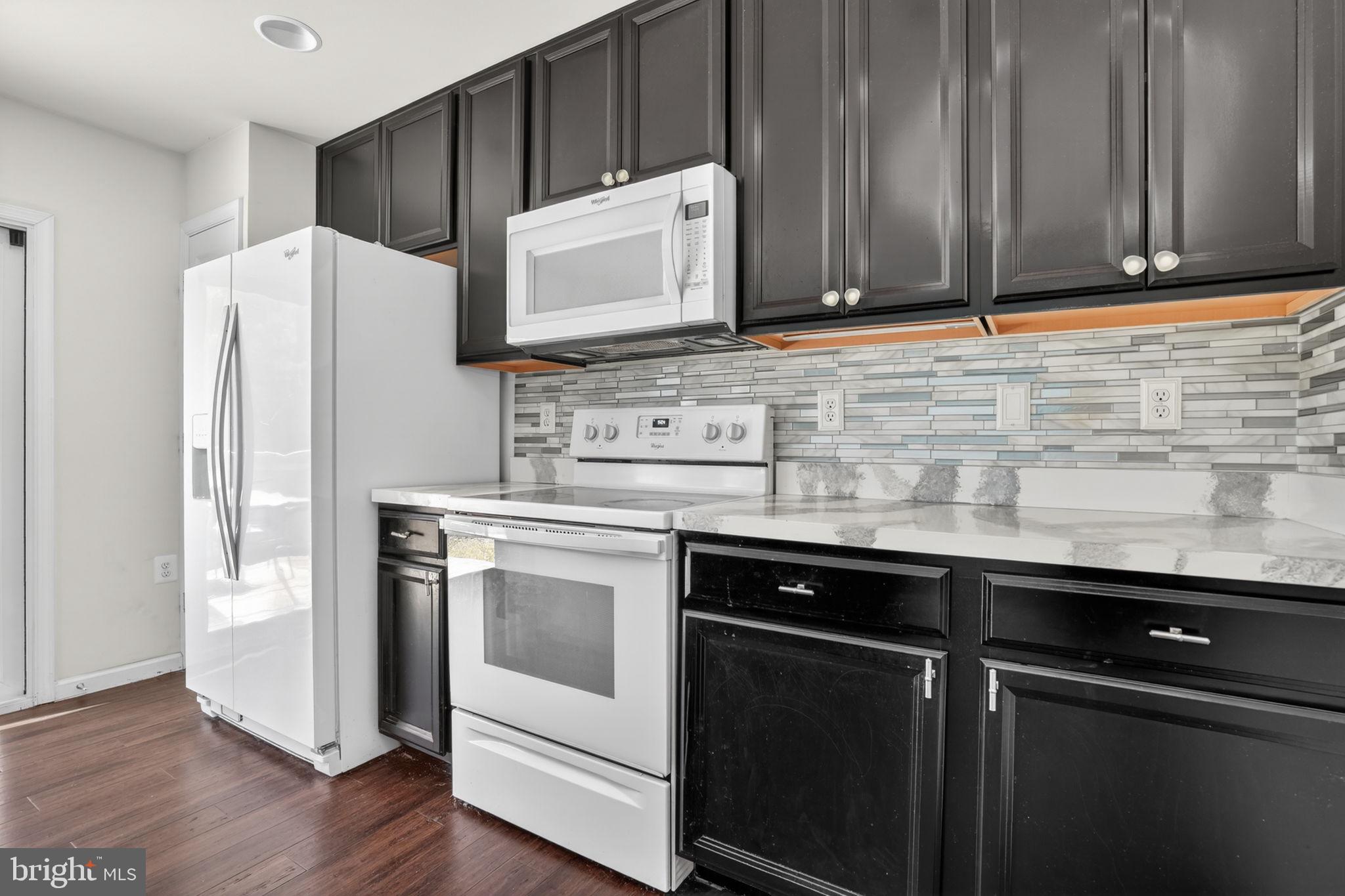 158 Intrepid Lane, Unit 92 Berlin, MD 21811 - Photo 7 of 37 a kitchen with granite countertop cabinets stainless steel appliances and wooden floor