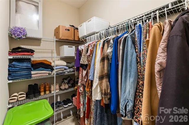 a view of walk in closet with clothes and shoes