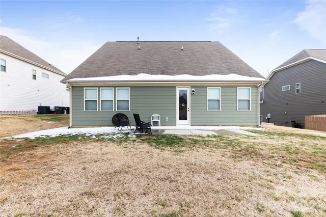 a view of a house with a yard and a large tree