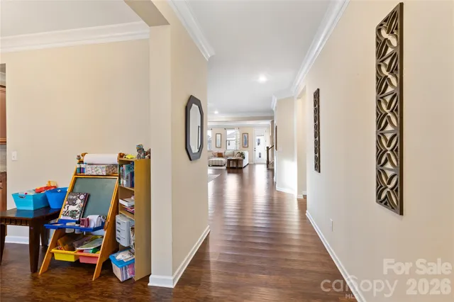 a view of a hallway with wooden floor and a workspace