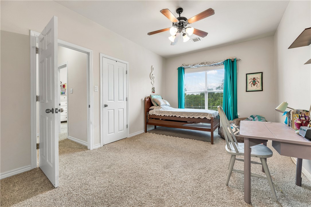 1425 West Villa Maria Road, Unit 1004 Bryan, TX 77801 - Photo 17 of 23 a bedroom with a bed and a chandelier