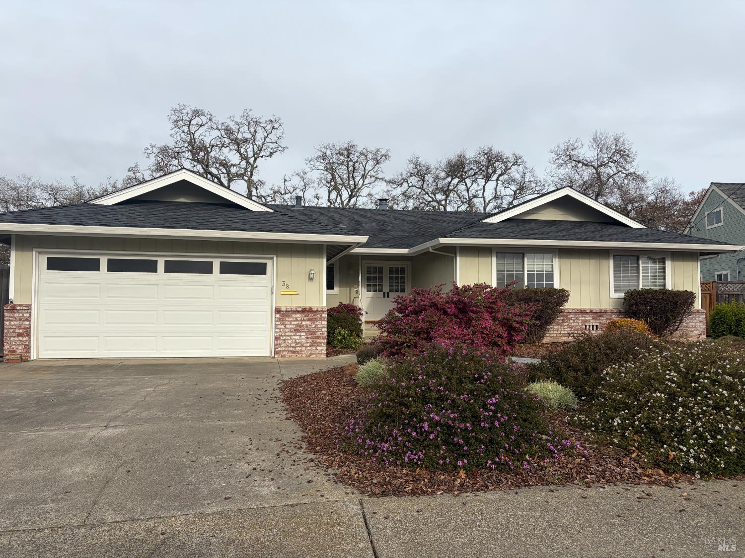 a front view of a house with a garden and yard