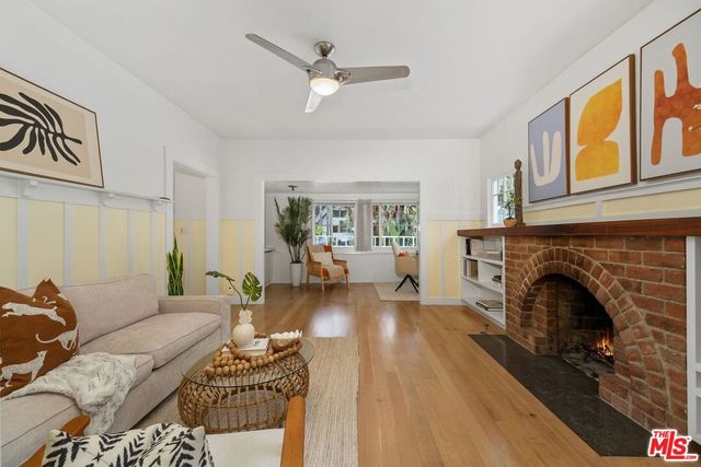 a living room with furniture a fireplace and a floor to ceiling window