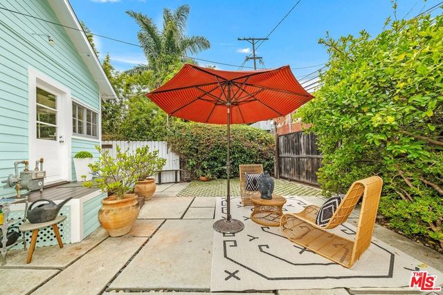 a view of a patio with table and chairs potted plants with wooden fence