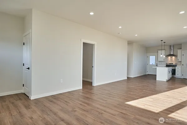 a kitchen with stainless steel appliances a sink a stove a refrigerator and white cabinets