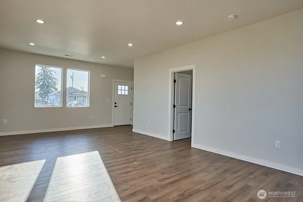 a kitchen with stainless steel appliances granite countertop a sink a stove a refrigerator and island with wooden floor