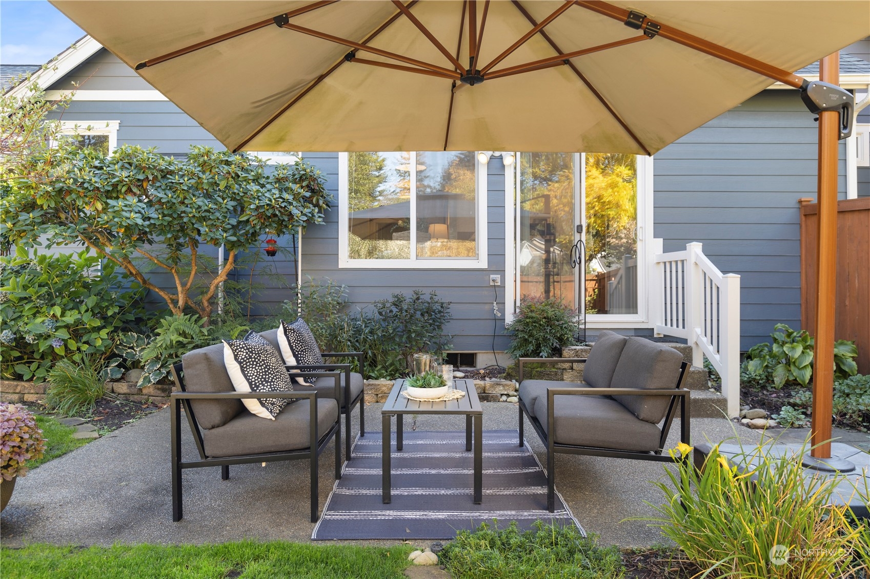 1460 Latham Court DuPont, WA 98327 - Photo 31 of 40 a view of a patio with couches table and chairs under an umbrella