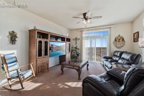 a living room with furniture ceiling fan and a window