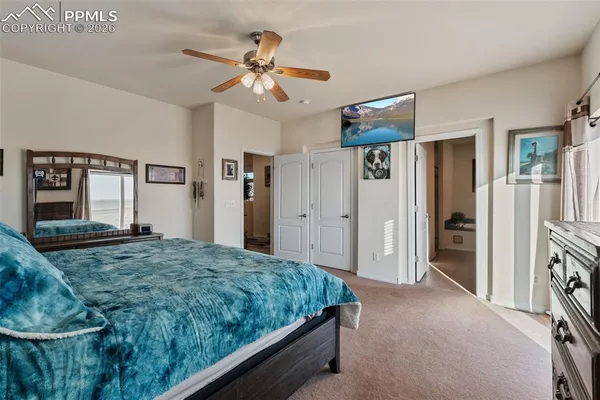 a spacious bedroom with a bed and dresser with mirror