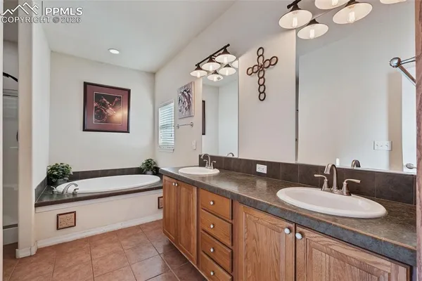 a bathroom with a granite countertop sink a large mirror and a bathtub