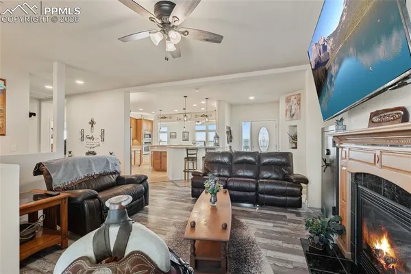 a living room with furniture kitchen view and a fireplace