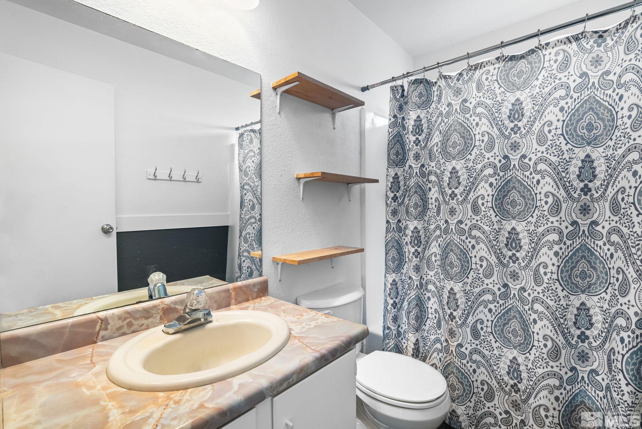 13968 Lear Boulevard Reno, NV 89506 - Photo 17 of 39 a bathroom with a sink toilet and shower