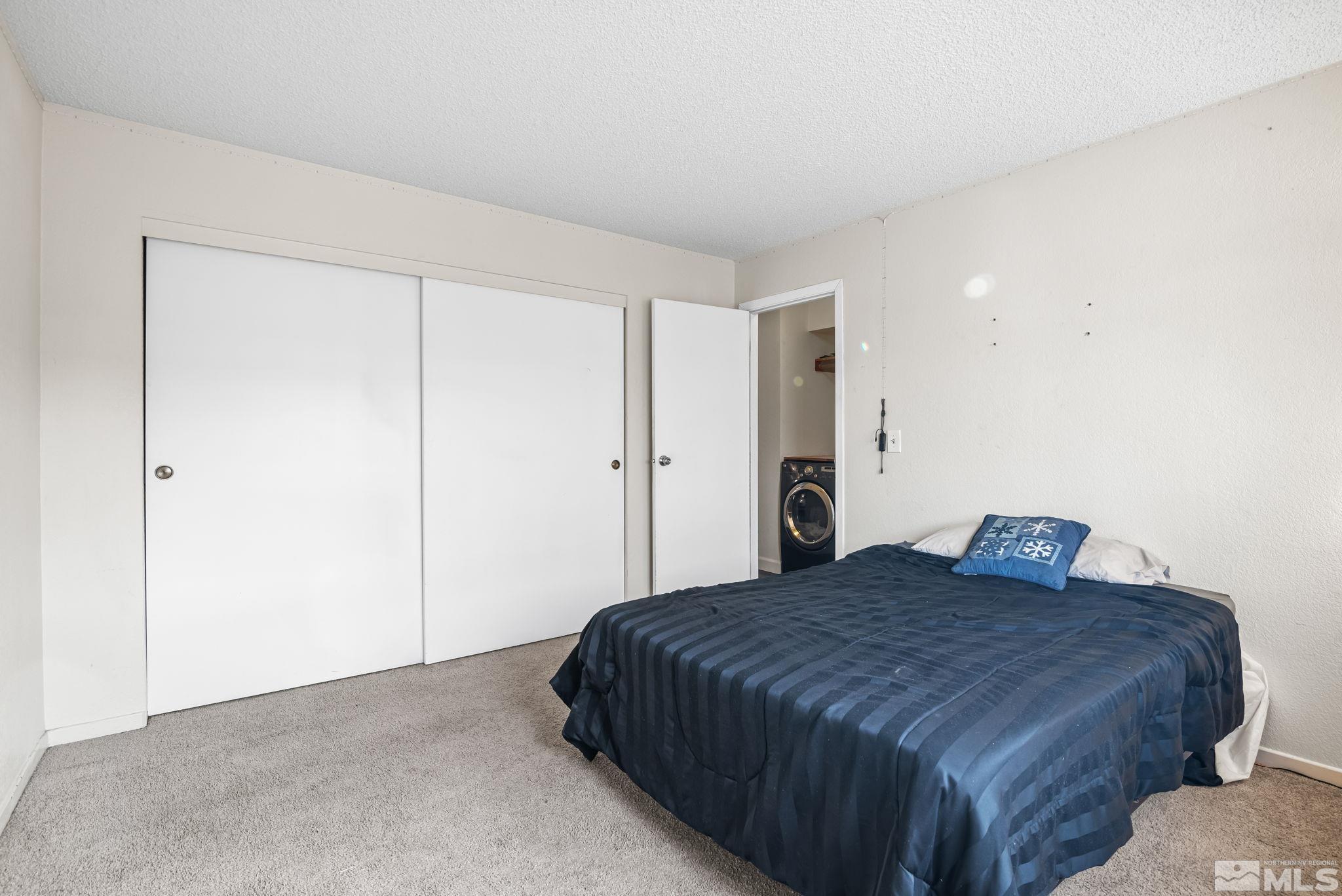 13968 Lear Boulevard Reno, NV 89506 - Photo 23 of 39 a bedroom with a large bed and a chandelier