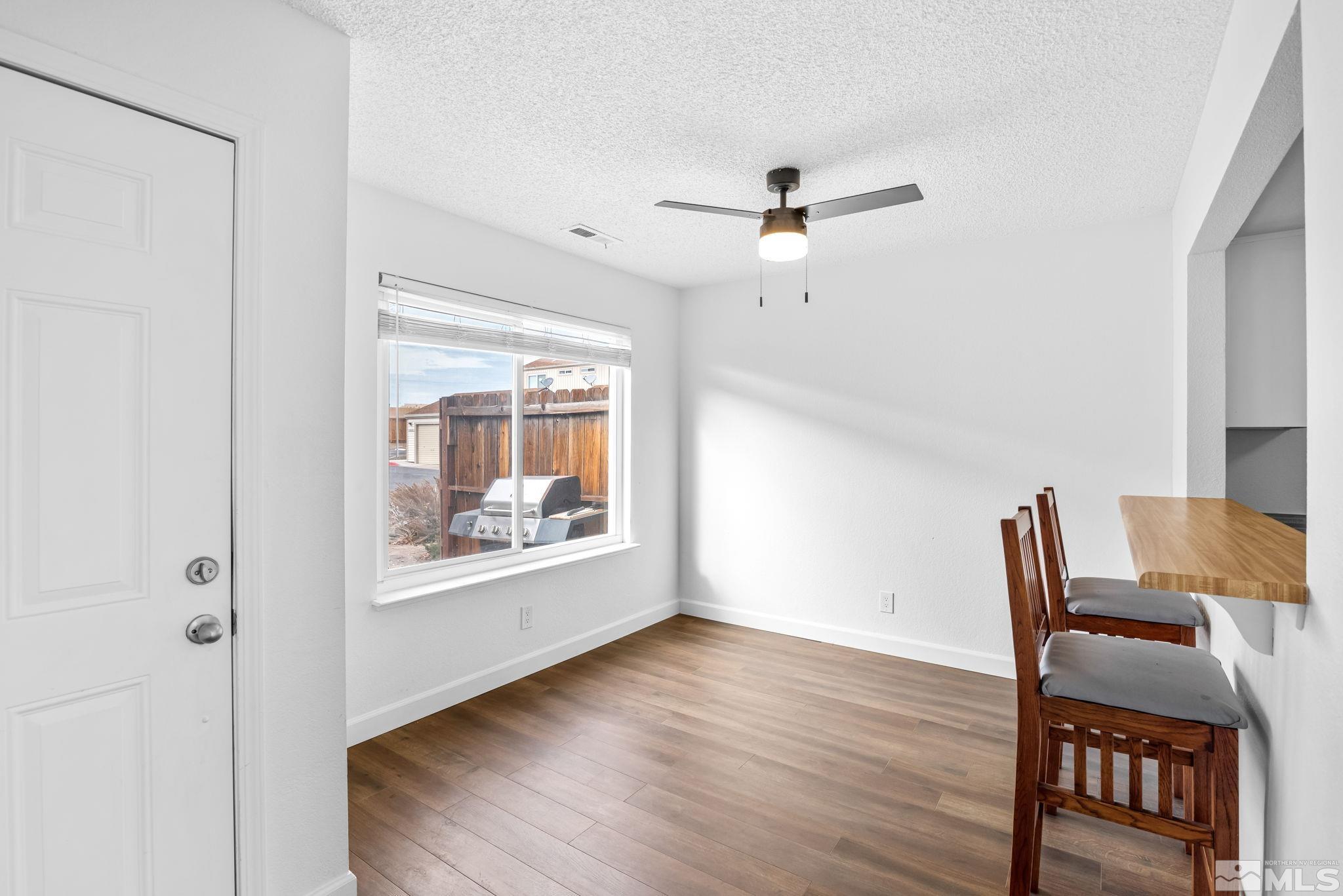 13968 Lear Boulevard Reno, NV 89506 - Photo 4 of 39 a workspace room with wooden floor fan and windows