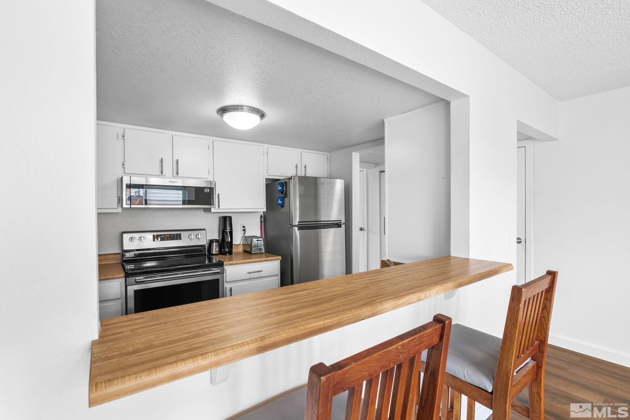 13968 Lear Boulevard Reno, NV 89506 - Photo 7 of 39 a kitchen with granite countertop a refrigerator stove top oven and sink