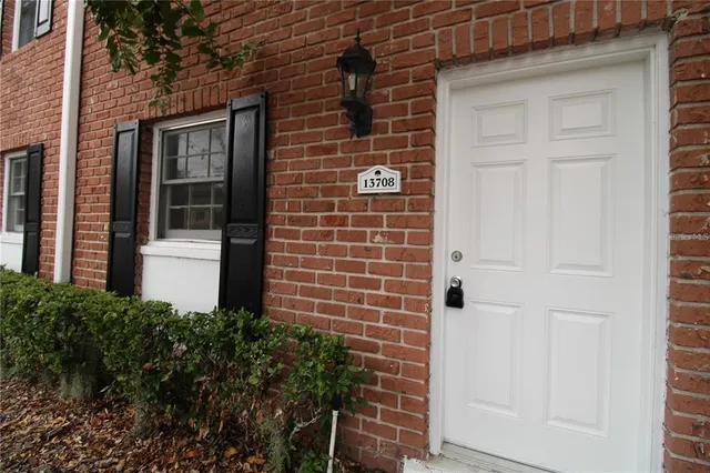 a brick house with a large windows and a yard space