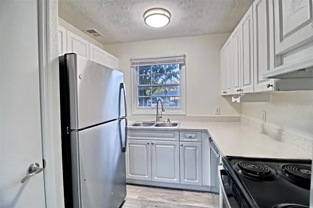 a kitchen with stainless steel appliances a refrigerator sink and cabinets