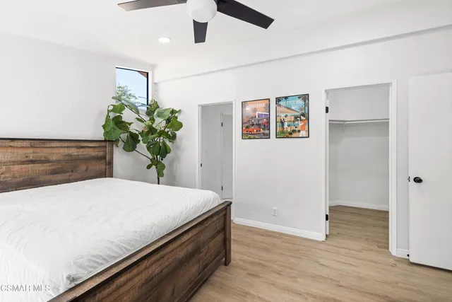 a bedroom with a bed and a potted plant