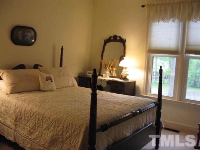 4201 Webster Court Raleigh, NC 27609 - Photo 12 of 25 a bed sitting in a bedroom next to a window