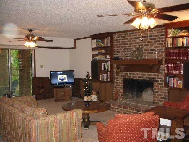 4201 Webster Court Raleigh, NC 27609 - Photo 14 of 25 a living room with furniture a chandelier and a fireplace