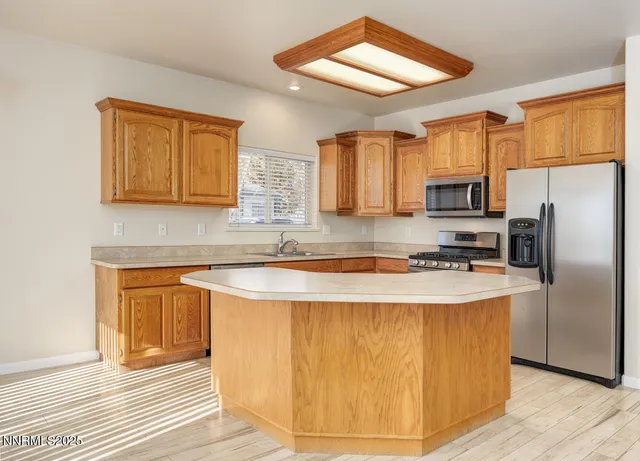 a kitchen with stainless steel appliances granite countertop a stove a sink dishwasher and a refrigerator