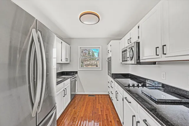 a kitchen with stainless steel appliances granite countertop a stove and a refrigerator