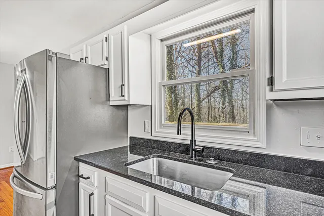 a kitchen with stainless steel appliances granite countertop a sink and a refrigerator