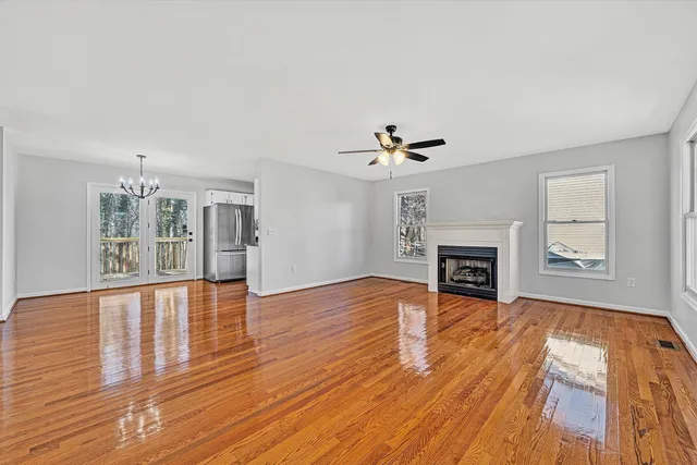 a view of empty room with wooden floor and fireplace