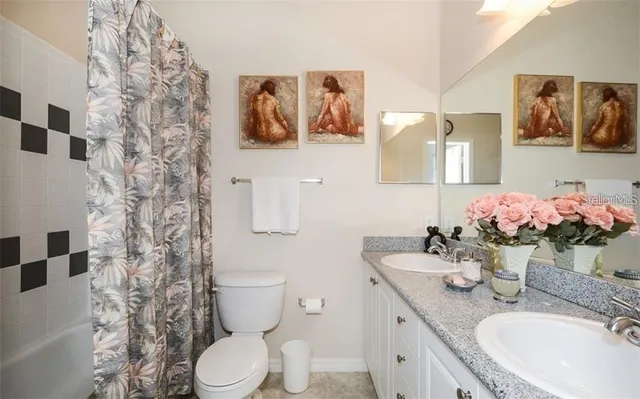 a bathroom with a granite countertop sink mirror and toilet