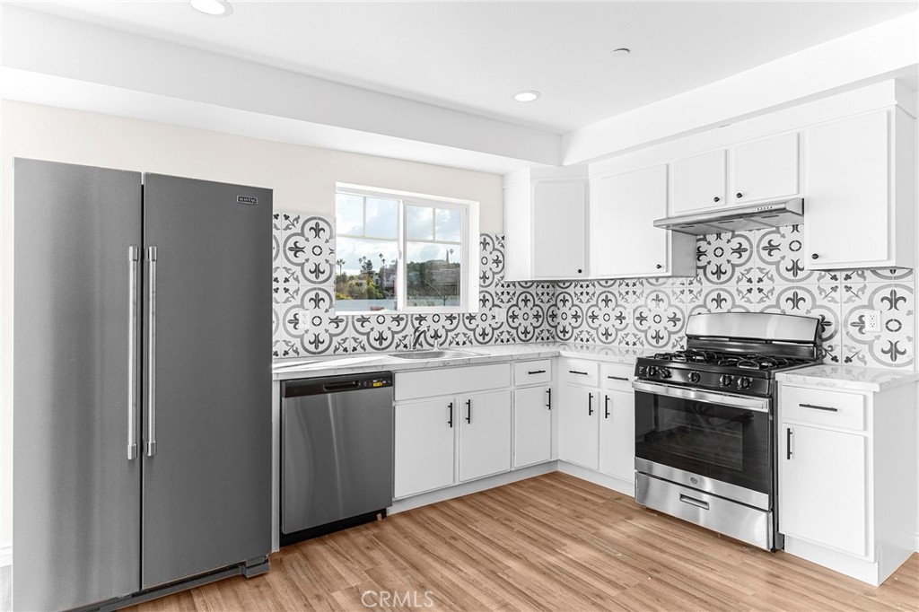 5639 Huntington Drive, Unit 1 Los Angeles, CA 90032 - Photo 9 of 25 a kitchen with stainless steel appliances granite countertop a stove a refrigerator and a stove