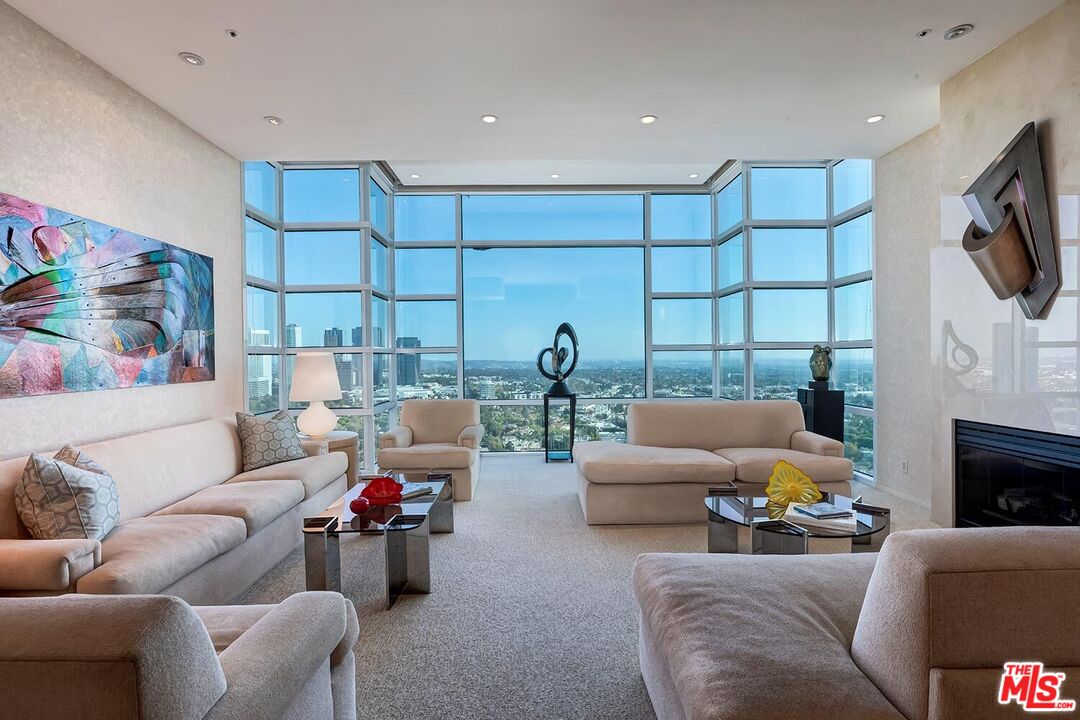 10380 Wilshire Boulevard, Unit 1703 Los Angeles, CA 90024 - Photo 4 of 34 a living room with furniture a fireplace and a flat screen tv
