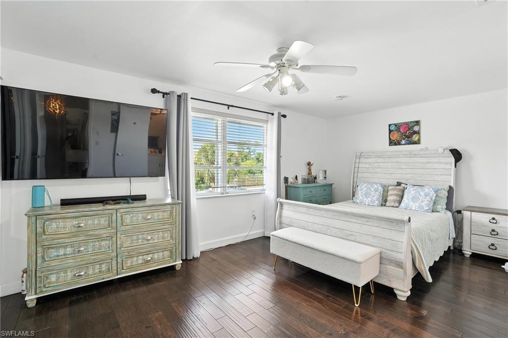 14 Watercolor Way, Unit 14 Naples, FL 34113 - Photo 13 of 37 a bedroom with a bed dresser and wooden floor