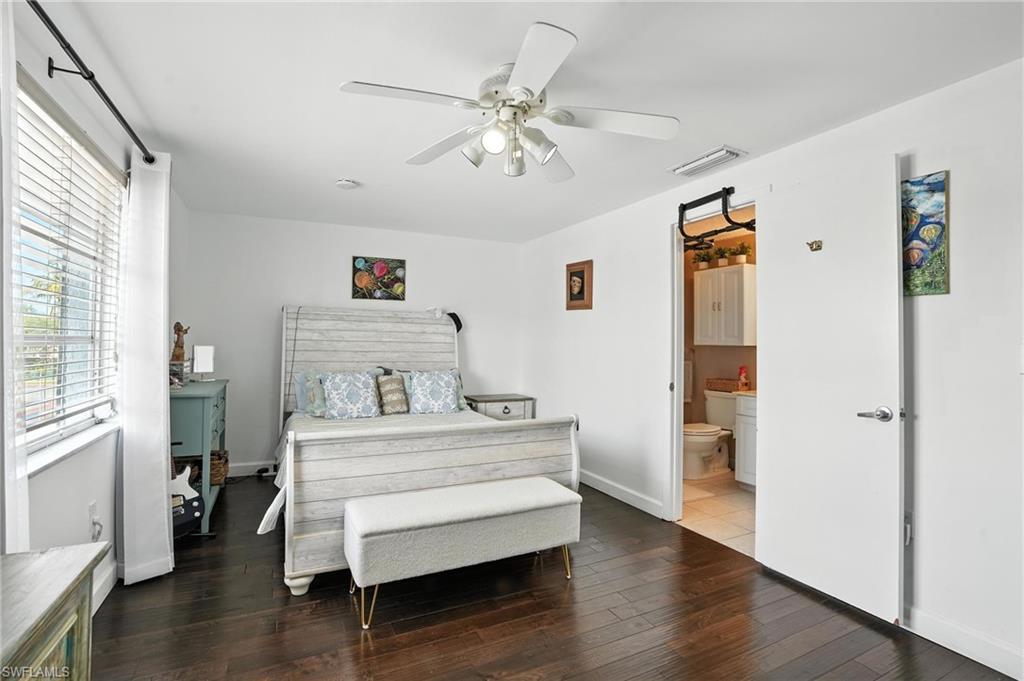 14 Watercolor Way, Unit 14 Naples, FL 34113 - Photo 15 of 37 a room with a bed and wooden floor