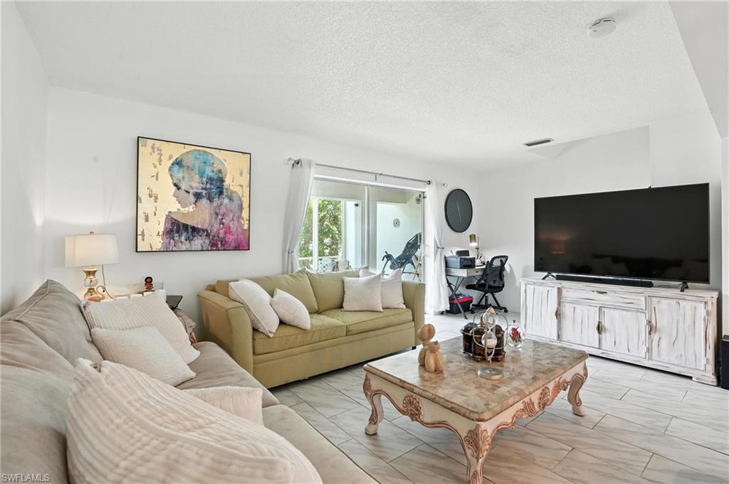 14 Watercolor Way, Unit 14 Naples, FL 34113 - Photo 2 of 37 a living room with furniture and a flat screen tv