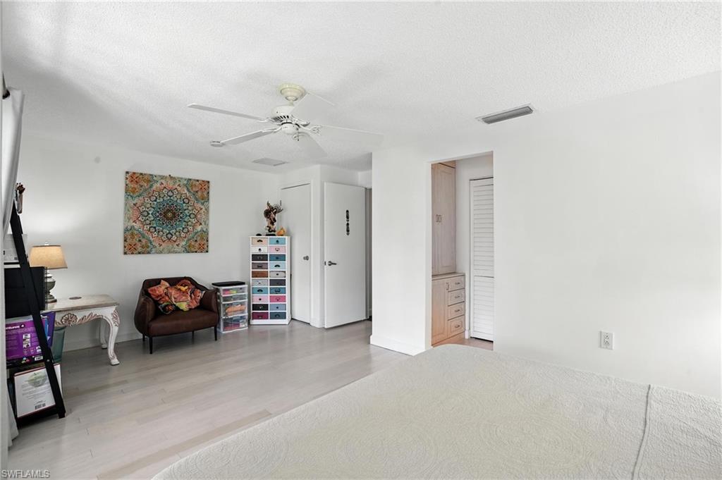 14 Watercolor Way, Unit 14 Naples, FL 34113 - Photo 21 of 37 a bedroom with furniture and a chandelier