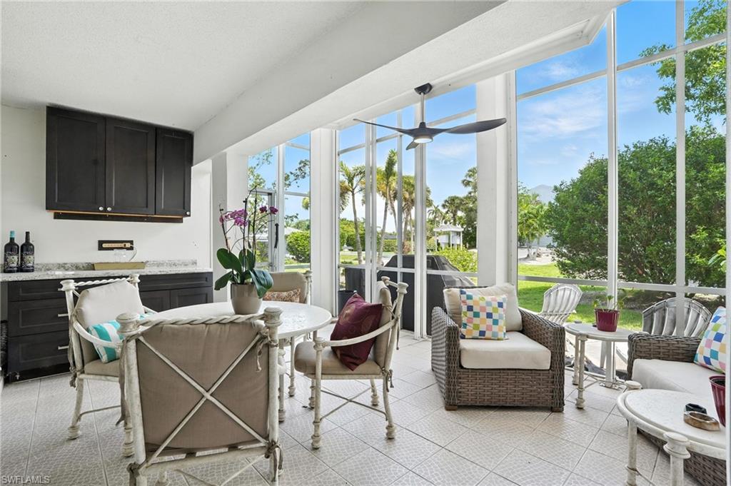 14 Watercolor Way, Unit 14 Naples, FL 34113 - Photo 25 of 37 a living room with furniture a flat screen tv and a floor to ceiling window
