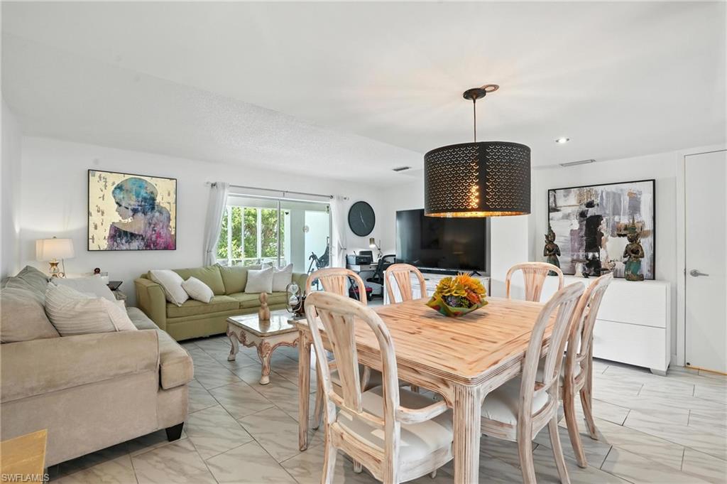 14 Watercolor Way, Unit 14 Naples, FL 34113 - Photo 7 of 37 a living room with furniture a window and a chandelier