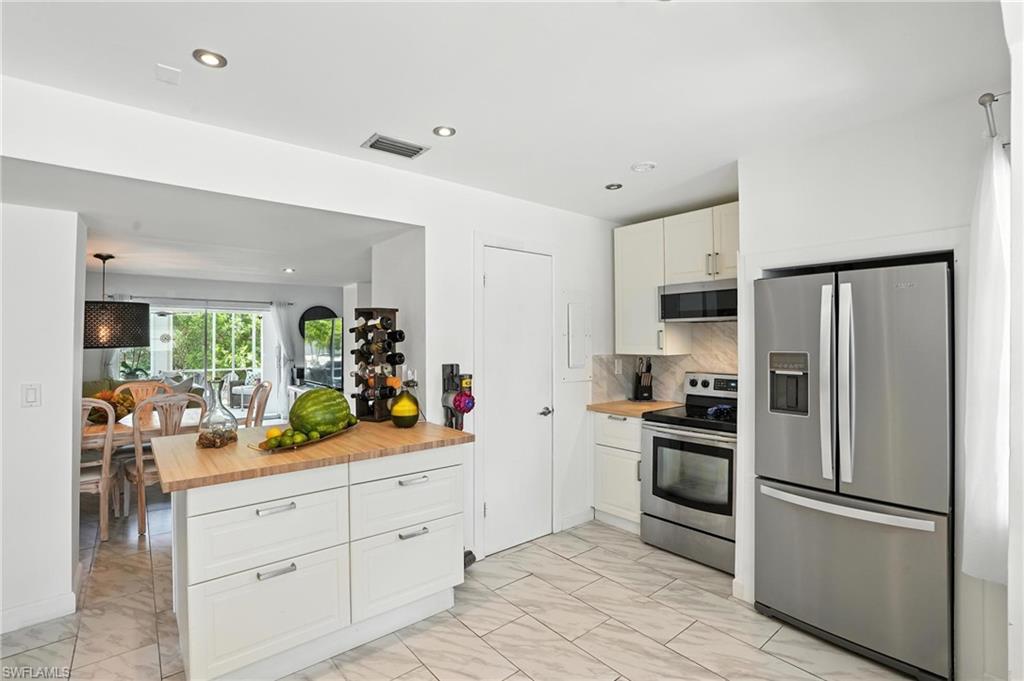 14 Watercolor Way, Unit 14 Naples, FL 34113 - Photo 10 of 37 a kitchen with white cabinets and stainless steel appliances