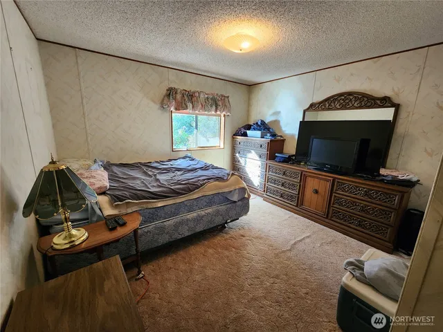 a bedroom with a bed and a flat screen tv