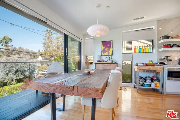 a view of a dining room with furniture a chandelier and wooden floor