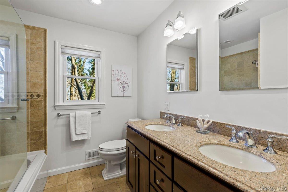 196 Old Army Road Scarsdale, NY 10583 - Photo 11 of 33 a bathroom with a granite countertop toilet a sink and a mirror