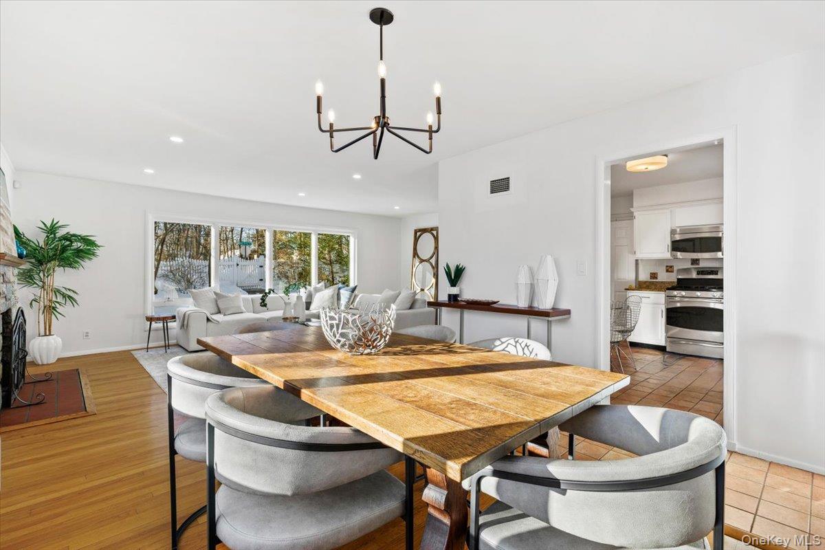 196 Old Army Road Scarsdale, NY 10583 - Photo 7 of 33 a dining room with wooden floor a chandelier a wooden table and chairs