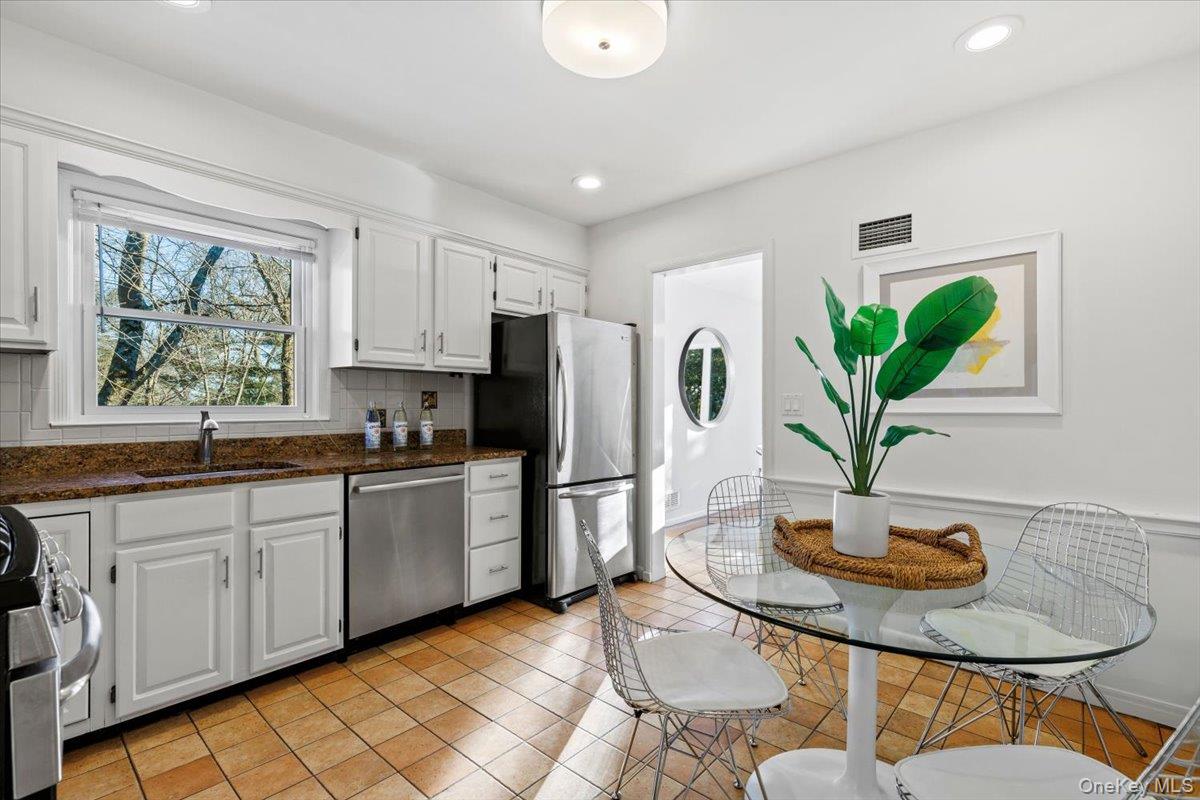 196 Old Army Road Scarsdale, NY 10583 - Photo 8 of 33 a kitchen with stainless steel appliances granite countertop a refrigerator a sink a stove a dining table and chairs